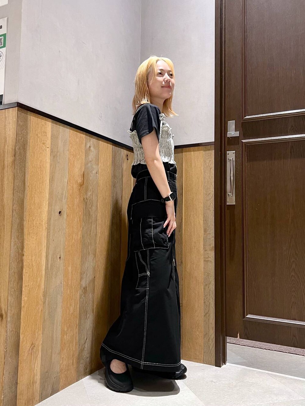 ブラック系のスニーカー、ブラック系のTシャツ/カットソー、ブラック系のデニムスカートを着用したレディースの夏コーディネートの2枚目の写真