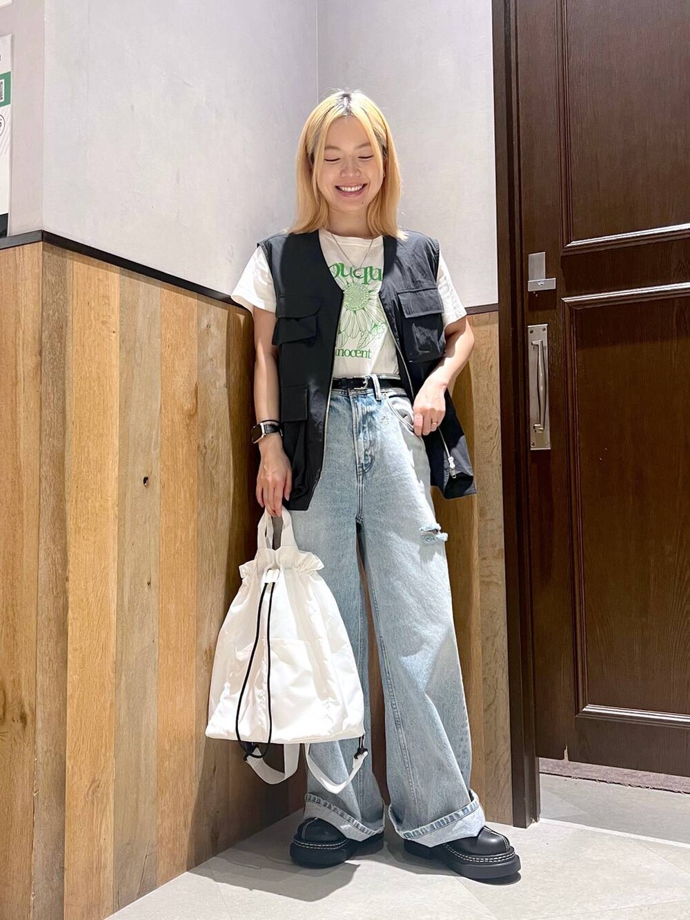 ホワイト系のショルダーバッグ、ホワイト系のTシャツ/カットソー、ブルー系のデニムパンツを着用したレディースの夏コーディネートの4枚目の写真