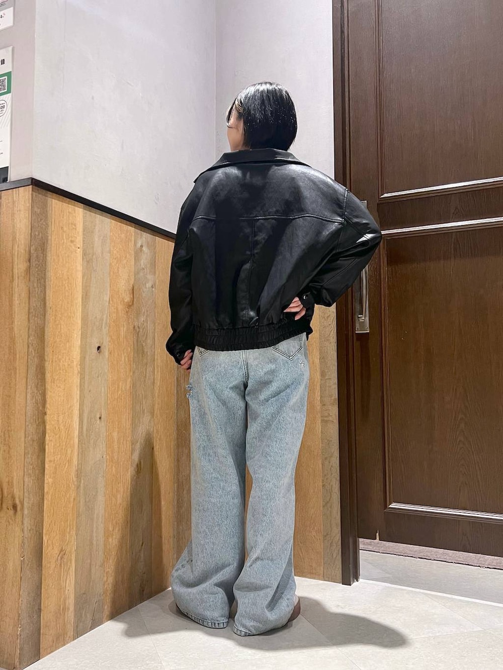 ブルー系のデニムパンツ、ブラック系のライダースジャケット、レッド系のTシャツ/カットソーを着用したレディースの秋コーディネートの4枚目の写真