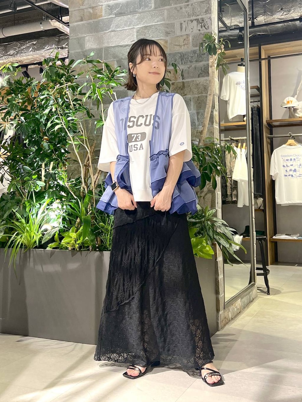 ホワイト系のTシャツ/カットソー、ブルー系のベスト、ブラック系のサンダルを着用したレディースの夏コーディネートの3枚目の写真