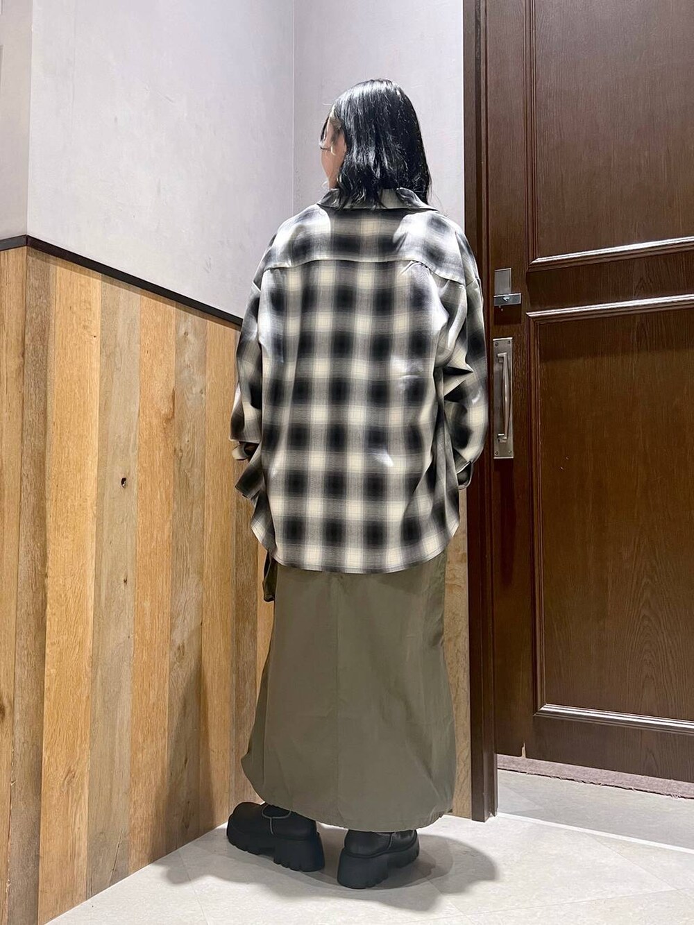 その他のTシャツ/カットソー、グリーン系のジャンパースカート、ブラック系のブーツを着用したレディースの秋コーディネートの3枚目の写真