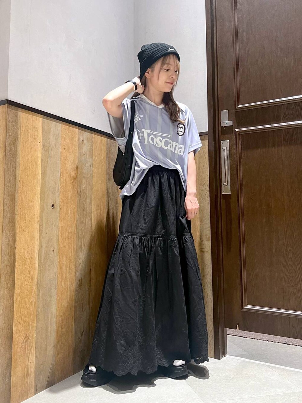 ブラック系のスカート、ブラック系のサンダル、ブルー系のTシャツ/カットソーを着用したレディースの夏コーディネートの4枚目の写真