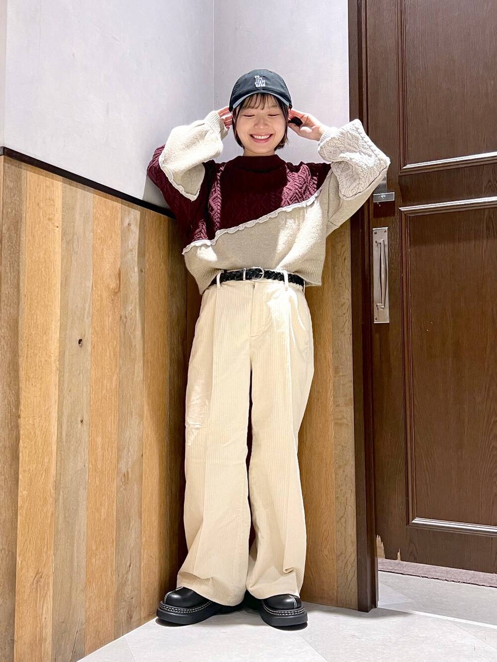 ホワイト系のスラックス、ブラック系のブルゾン、ブラック系のローファーを着用したレディースの秋コーディネートの4枚目の写真