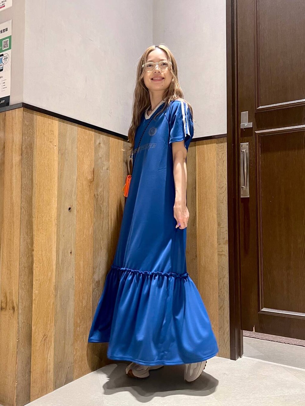 ホワイト系のワンピース、ホワイト系のスニーカー、オレンジ系のコインケースを着用したレディースの夏コーディネートの4枚目の写真