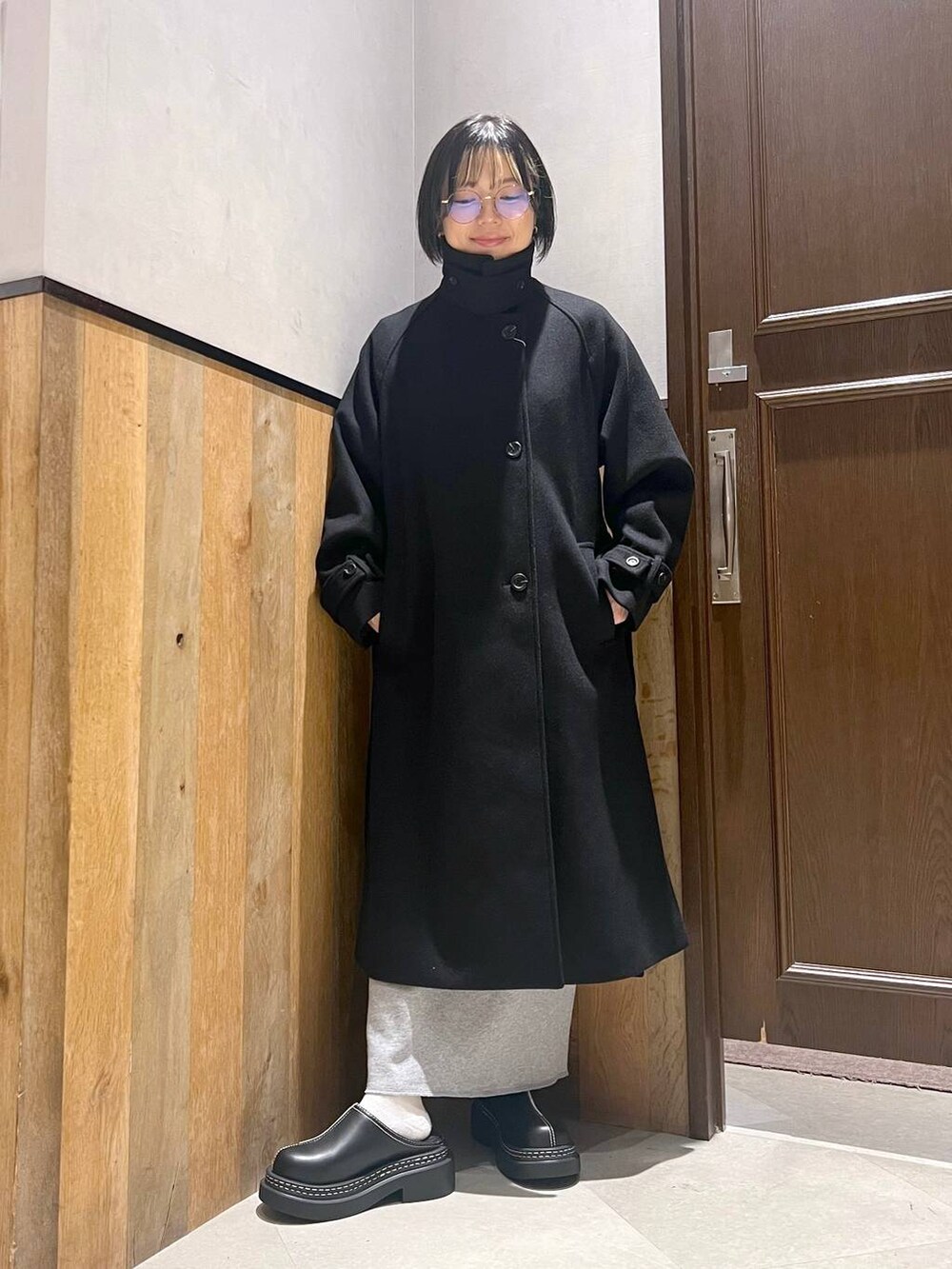 ブラック系のステンカラーコート、ブラック系のローファー、その他のスカートを着用したレディースの秋コーディネートの4枚目の写真