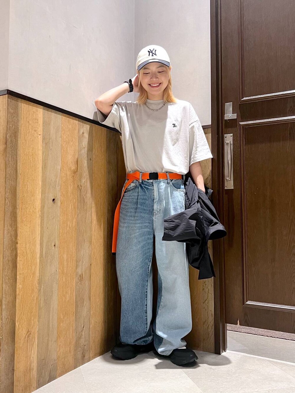 ブラック系のスニーカー、ブルー系のデニムパンツ、ブラック系のシャツ/ブラウスを着用したレディースの夏コーディネートの2枚目の写真