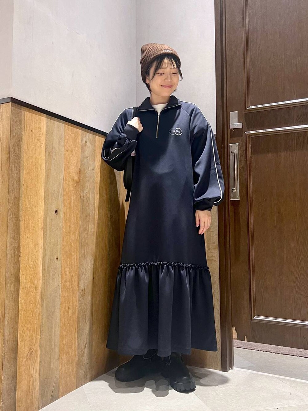 ブラック系のショルダーバッグ、ホワイト系のTシャツ/カットソー、ブラック系のブーツを着用したレディースの秋コーディネートの4枚目の写真