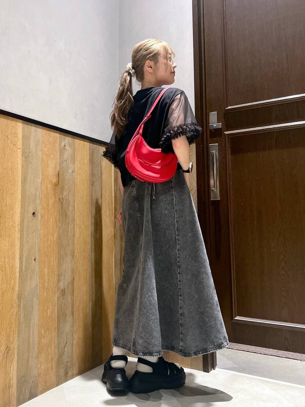 ブラック系のワンピース、ブラック系のTシャツ/カットソー、ブラック系のサンダルを着用したレディースの夏コーディネートの3枚目の写真