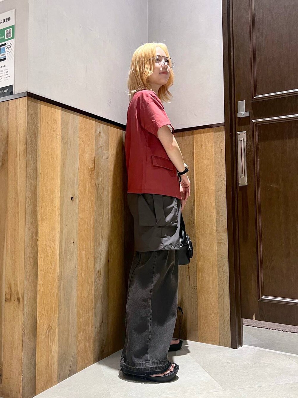 グレー系のスカート、ブラック系のデニムパンツ、レッド系のシャツ/ブラウスを着用したレディースの夏コーディネートの3枚目の写真