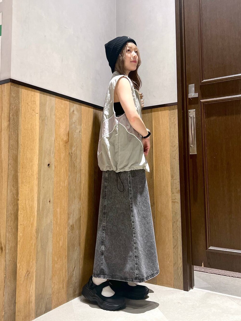 ブラック系のスニーカー、ブラック系のワンピース、グレー系のベストを着用したレディースの夏コーディネートの2枚目の写真