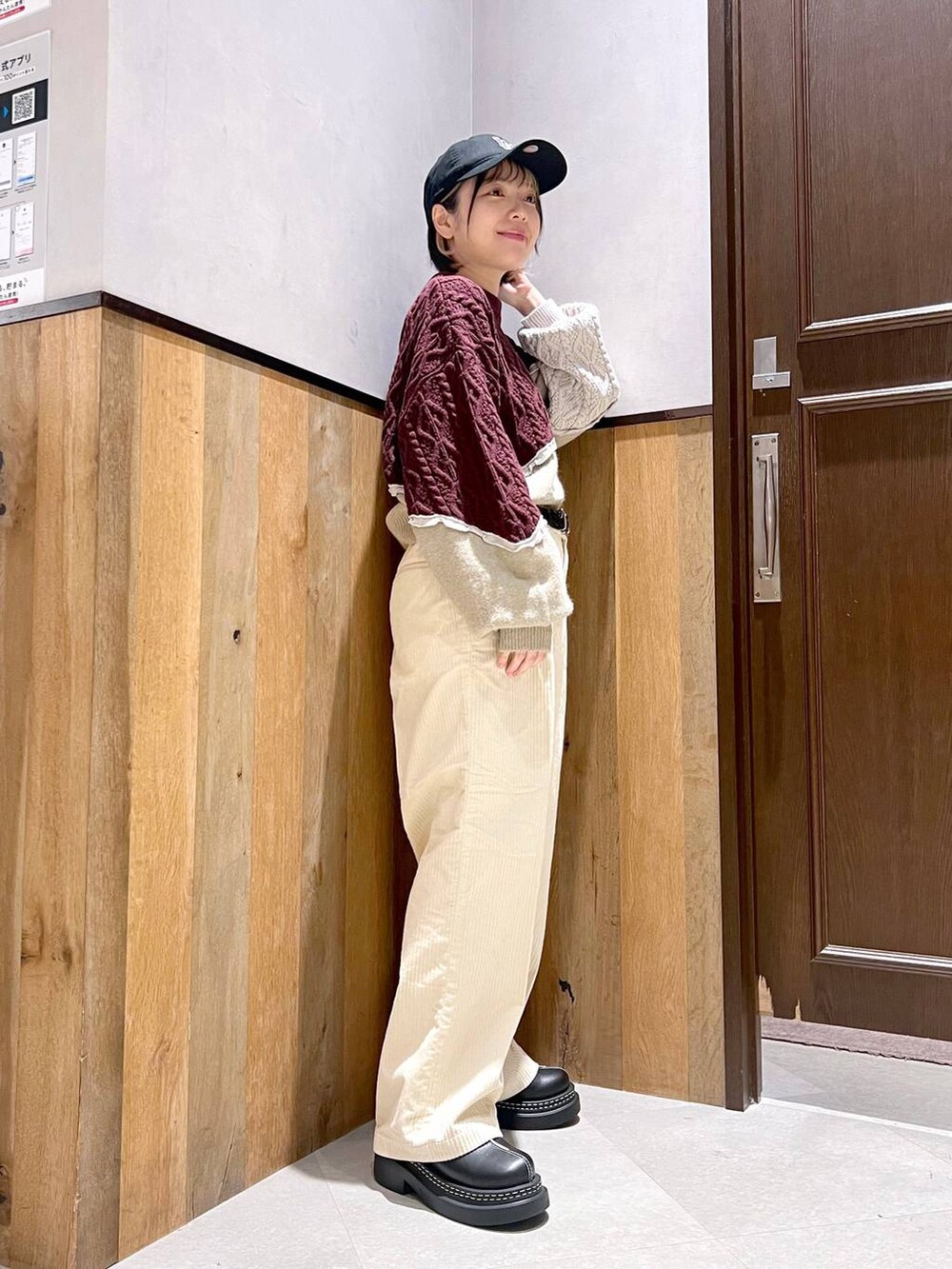 ホワイト系のスラックス、ブラック系のブルゾン、ブラック系のローファーを着用したレディースの秋コーディネートの5枚目の写真