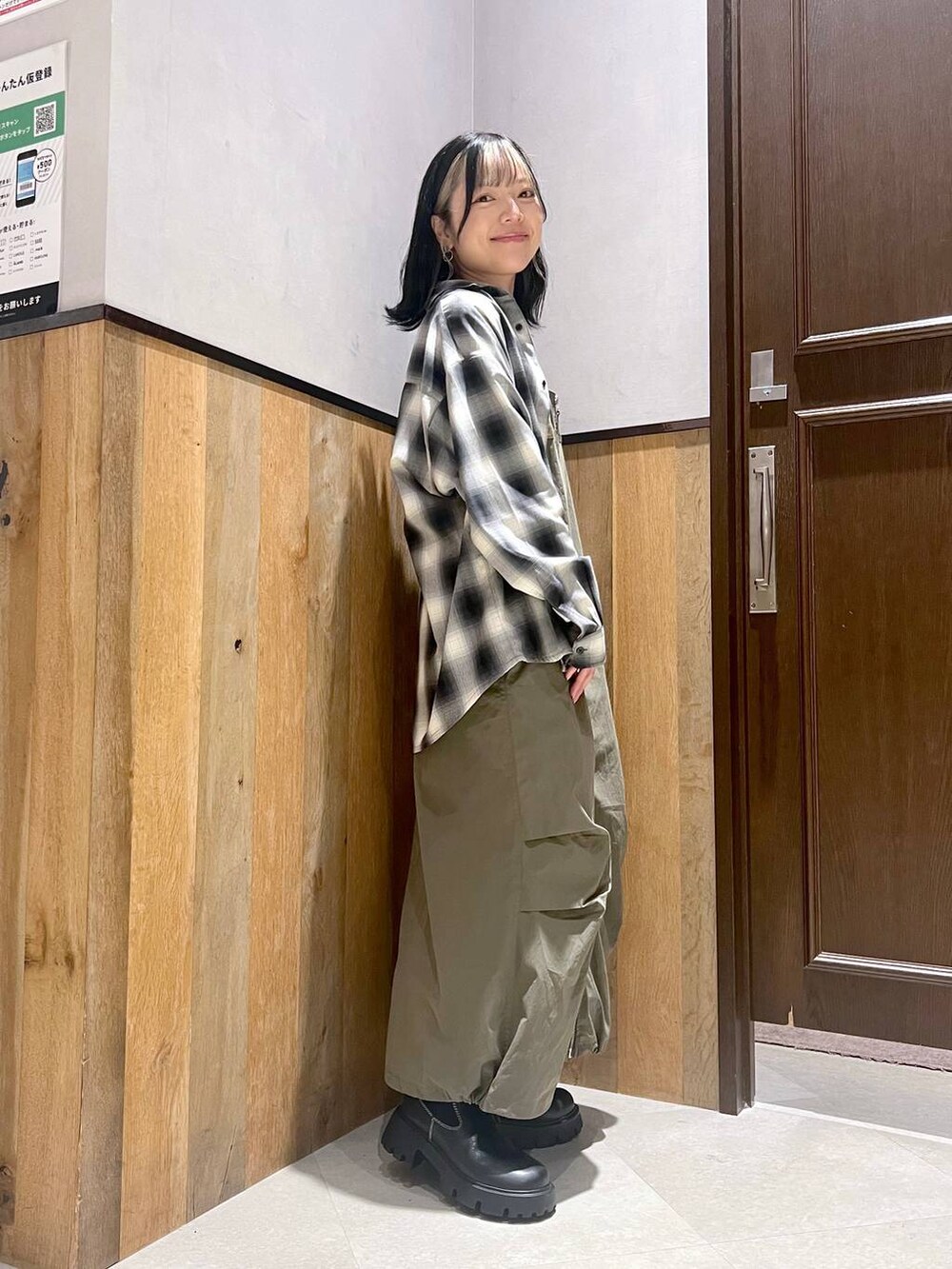 その他のTシャツ/カットソー、グリーン系のジャンパースカート、ブラック系のブーツを着用したレディースの秋コーディネートの2枚目の写真