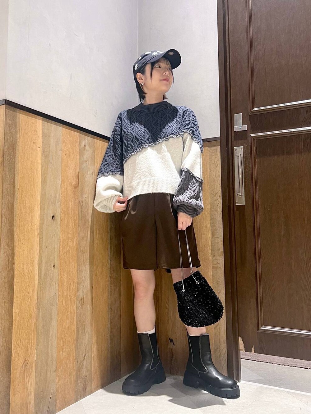 ホワイト系のダウンジャケット/コート、ブラック系のブーツ、ブラック系のハンドバッグを着用したレディースの秋コーディネートの5枚目の写真