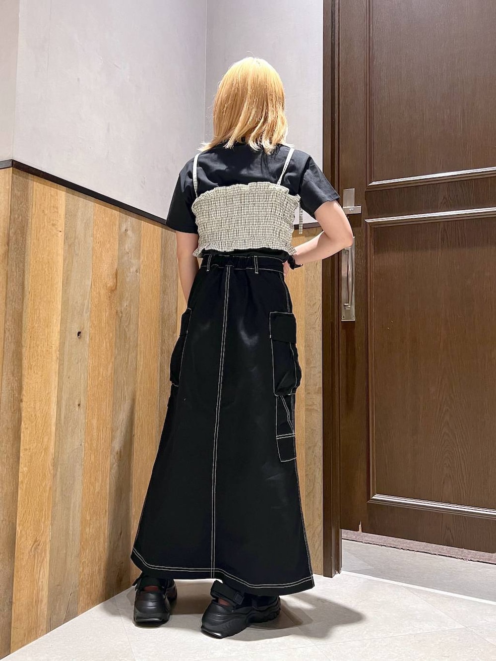 ブラック系のスニーカー、ブラック系のTシャツ/カットソー、ブラック系のデニムスカートを着用したレディースの夏コーディネートの3枚目の写真