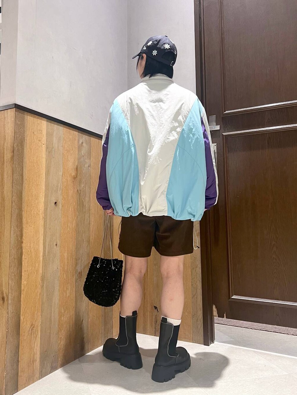 ホワイト系のダウンジャケット/コート、ブラック系のブーツ、ブラック系のハンドバッグを着用したレディースの秋コーディネートの4枚目の写真