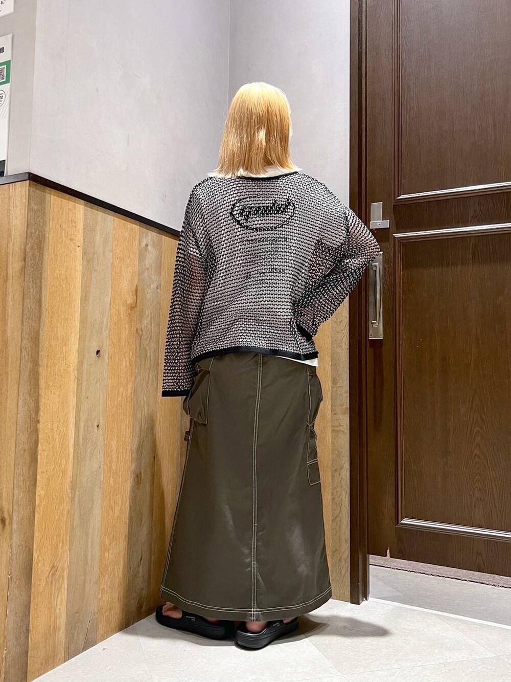 ブラック系のサンダル、ホワイト系のTシャツ/カットソー、グリーン系のデニムスカートを着用したレディースの夏コーディネートの3枚目の写真