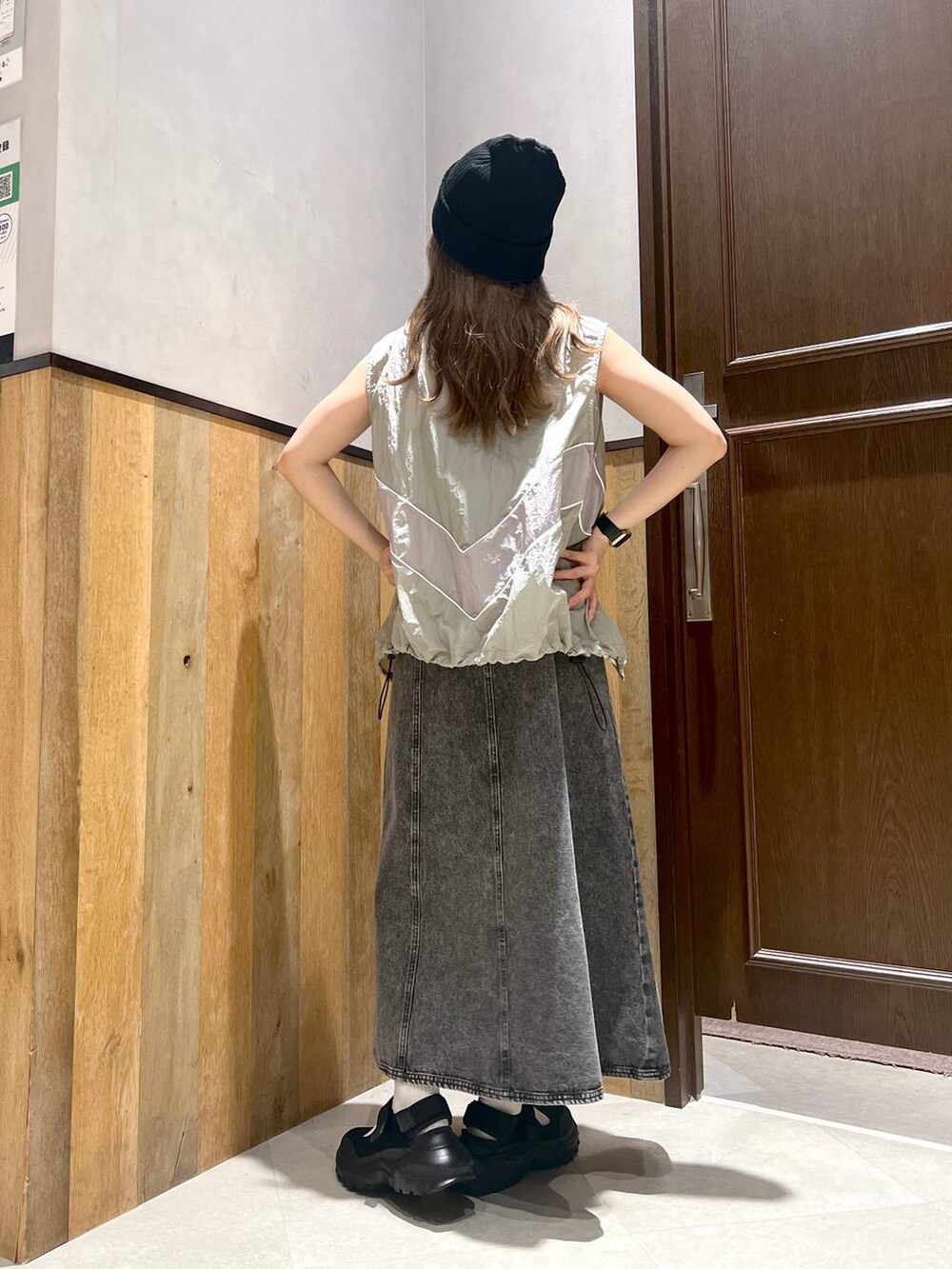 ブラック系のスニーカー、ブラック系のワンピース、グレー系のベストを着用したレディースの夏コーディネートの3枚目の写真