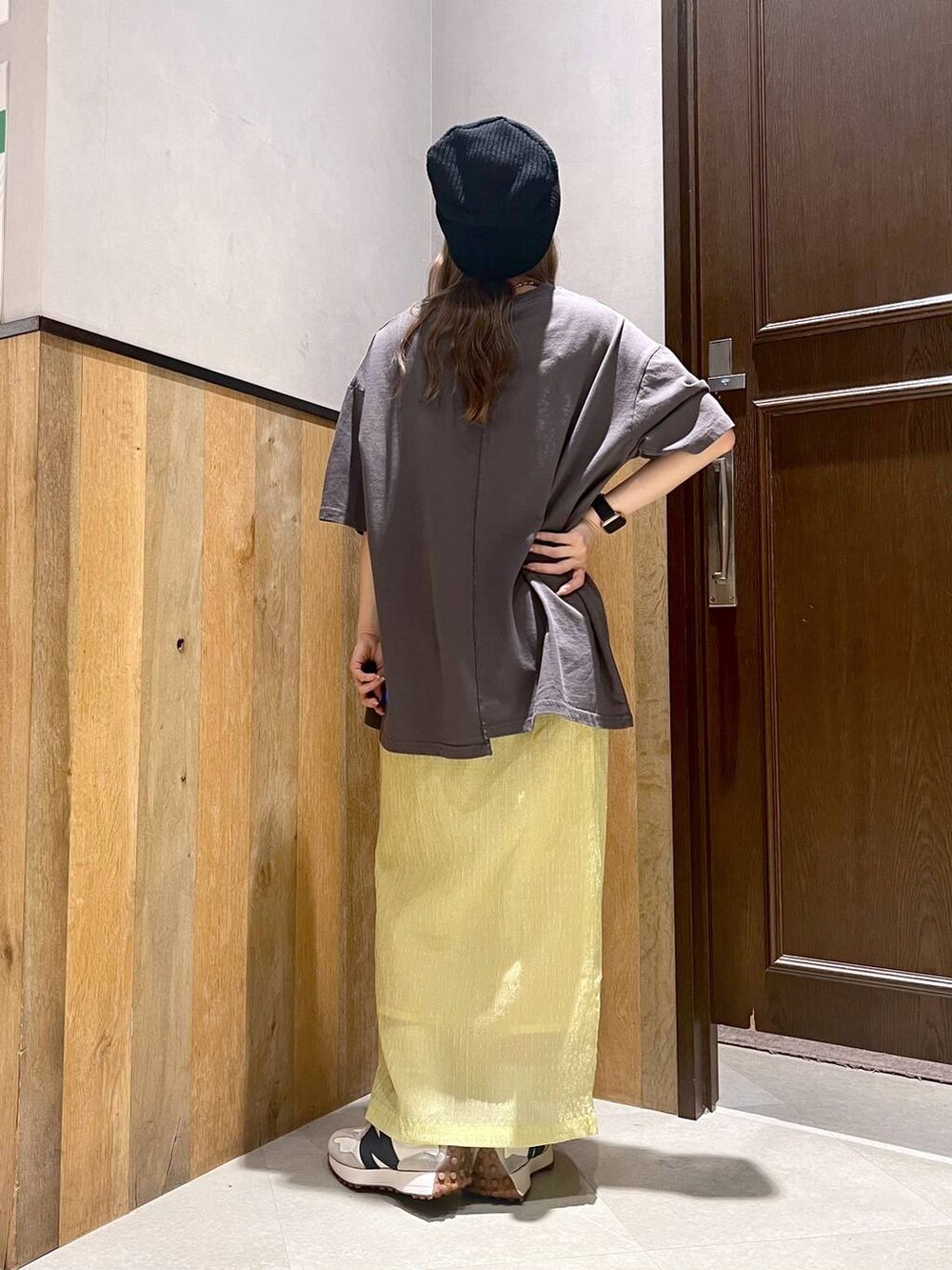 ホワイト系のスニーカー、ブラック系のTシャツ/カットソー、イエロー系のスカートを着用したレディースの夏コーディネートの3枚目の写真