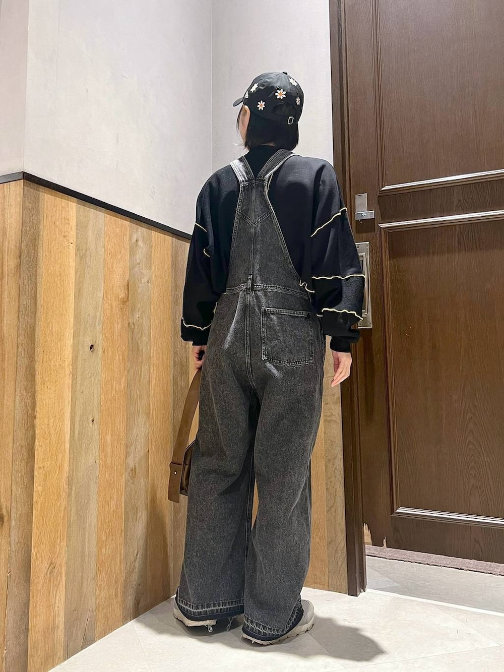 ブラック系のサロペット/オーバーオール、ブラック系のスウェット、グレー系のスニーカーを着用したレディースの秋コーディネートの3枚目の写真