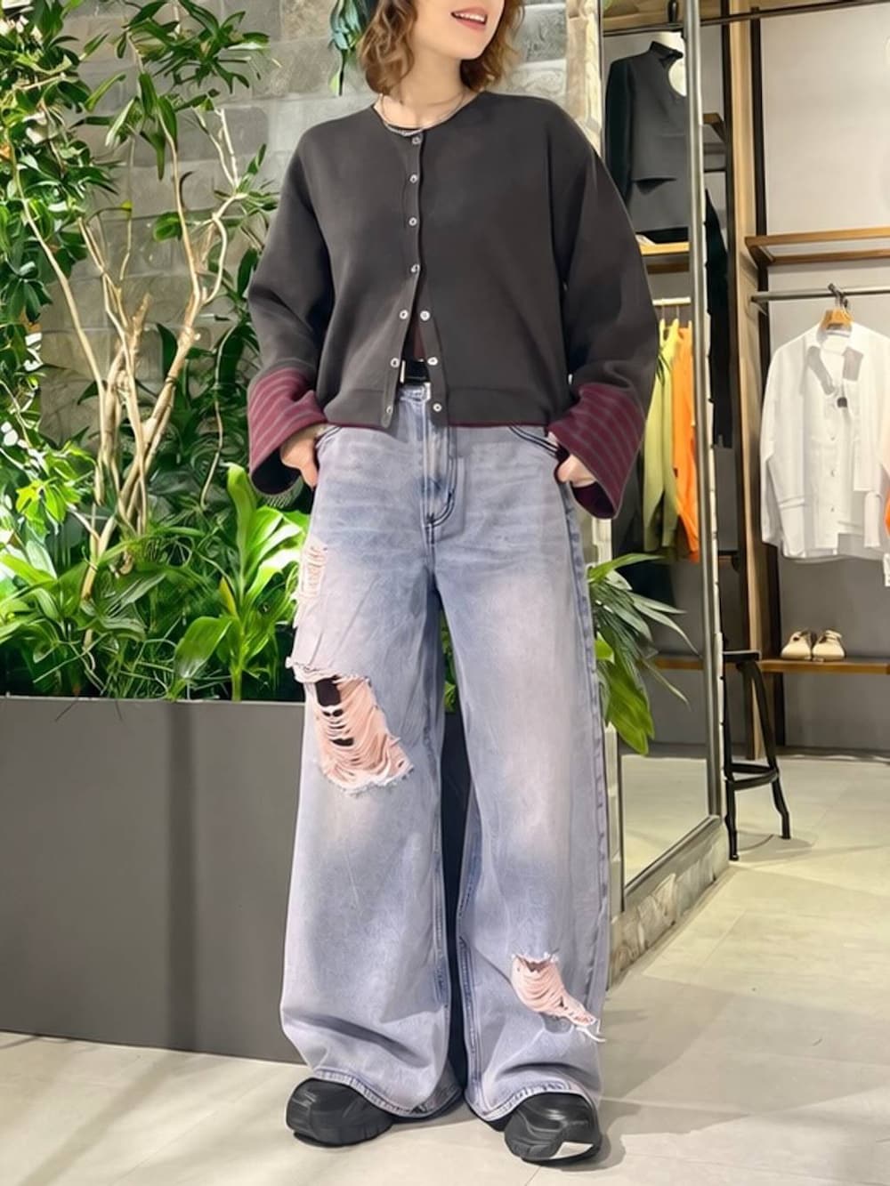 ブラック系のスリッポン、グレー系のカーディガン/ボレロ、ピンク系のデニムパンツを着用したレディースの秋コーディネートの2枚目の写真