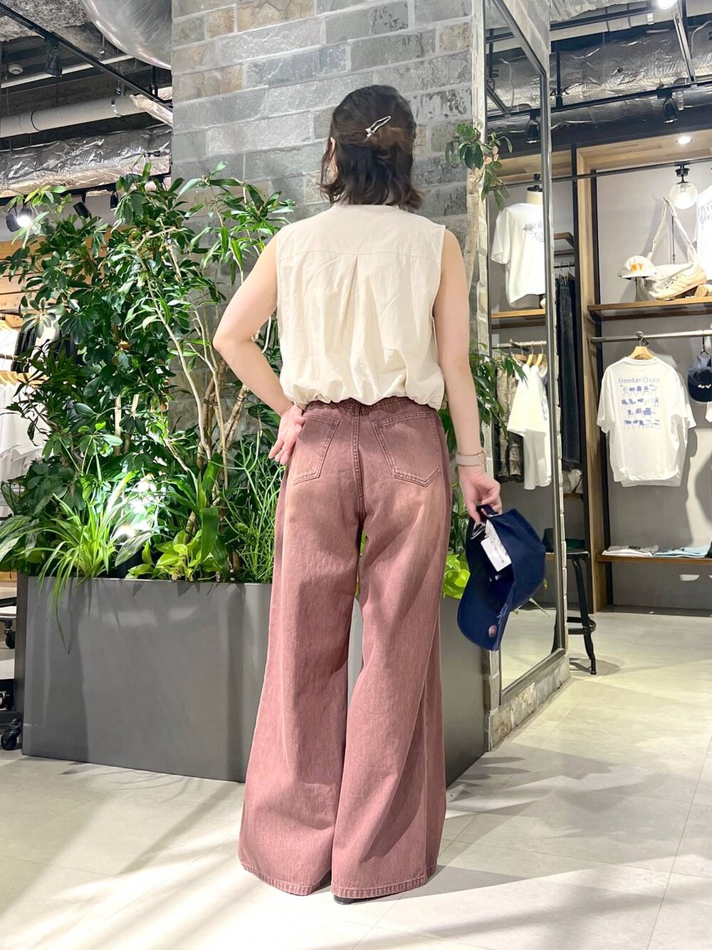 ホワイト系のベスト、ブラック系のサンダル、レッド系のデニムパンツを着用したレディースの夏コーディネートの4枚目の写真