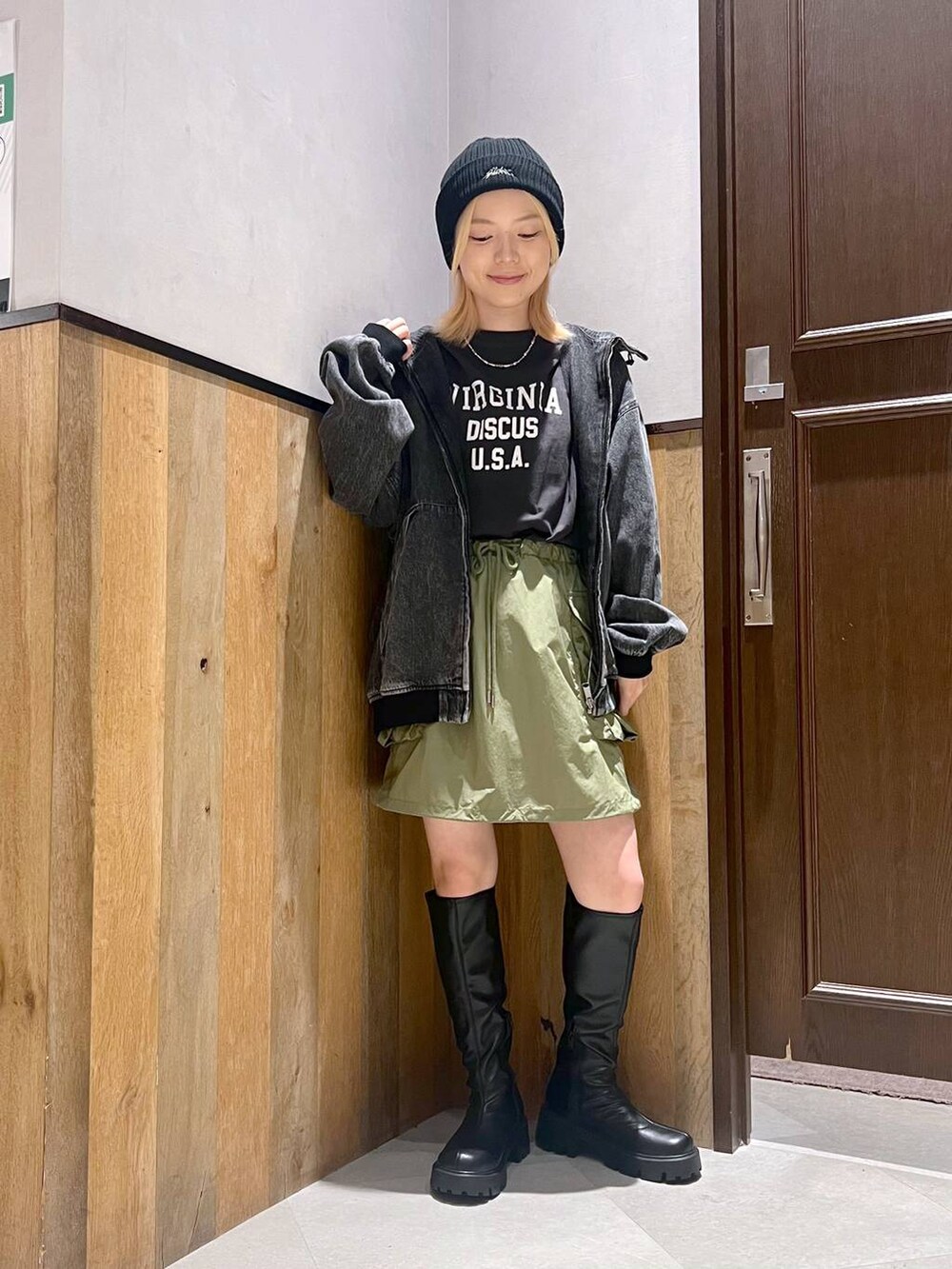 グレー系のブルゾン、グリーン系のスカート、ブラック系のTシャツ/カットソーを着用したレディースの夏コーディネートの4枚目の写真