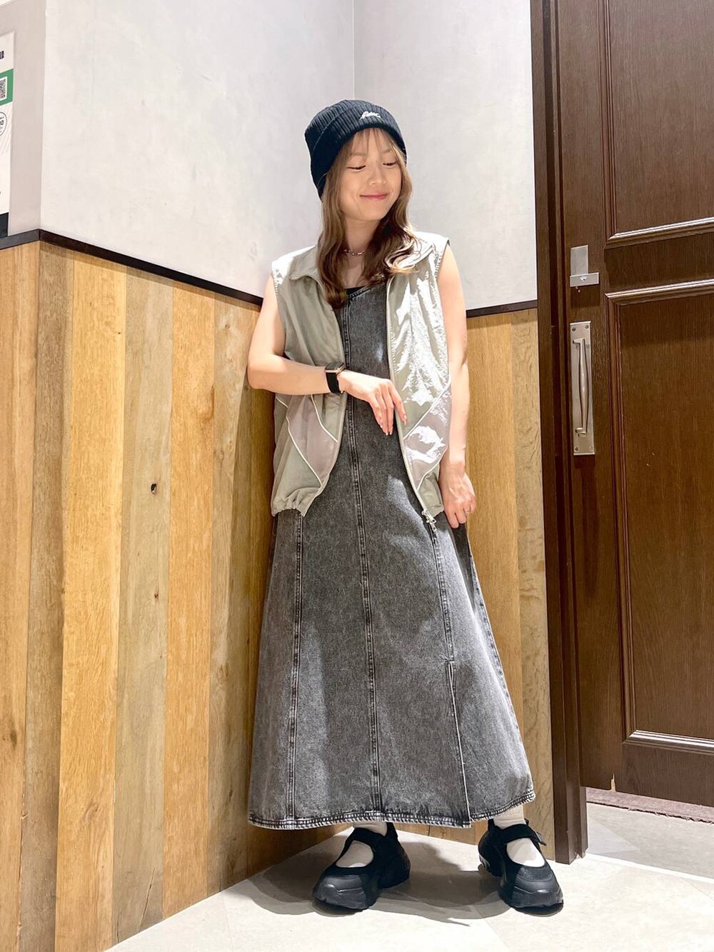 ブラック系のスニーカー、ブラック系のワンピース、グレー系のベストを着用したレディースの夏コーディネートの4枚目の写真