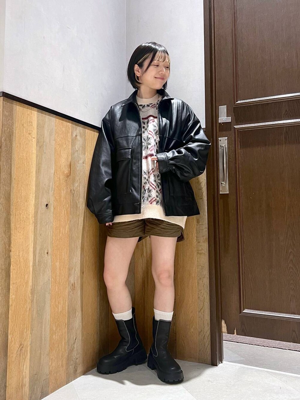 ブラック系のブーツ、ホワイト系のニット/セーター、ブラック系のブルゾンを着用したレディースの秋コーディネートの2枚目の写真