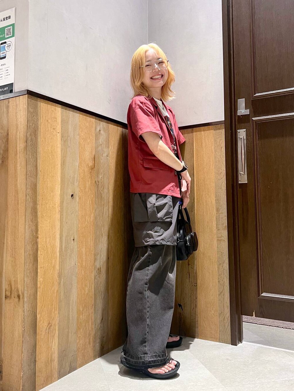 グレー系のスカート、ブラック系のデニムパンツ、レッド系のシャツ/ブラウスを着用したレディースの夏コーディネートの4枚目の写真