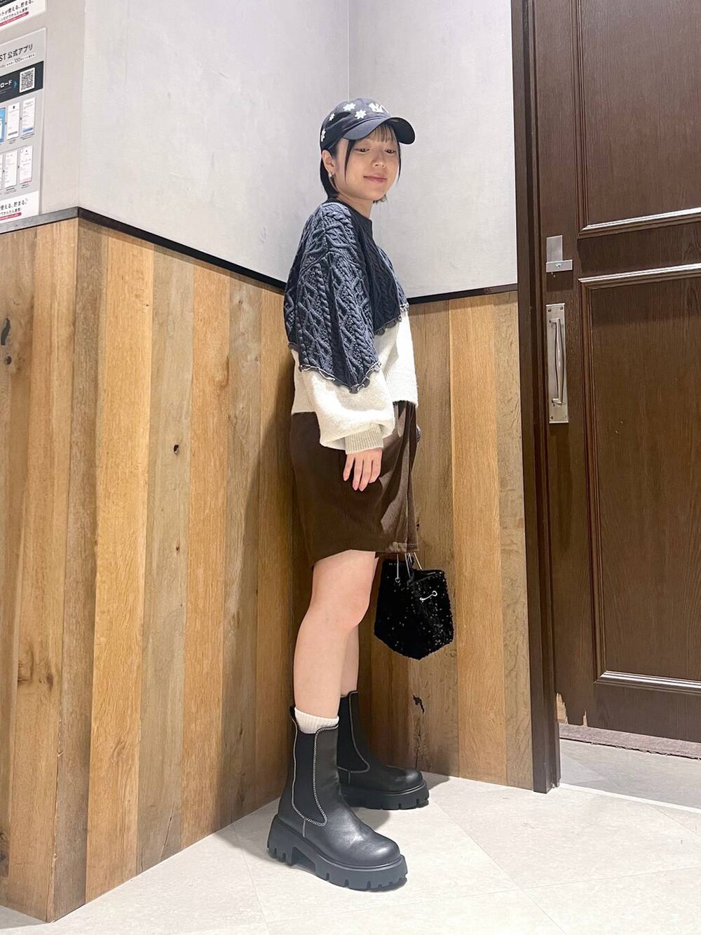 ホワイト系のダウンジャケット/コート、ブラック系のブーツ、ブラック系のハンドバッグを着用したレディースの秋コーディネートの6枚目の写真