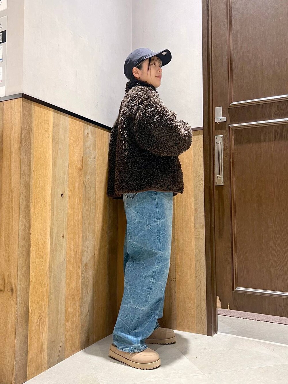 ホワイト系のニット/セーター、ブラウン系のブルゾン、ブルー系のデニムパンツを着用したレディースの秋コーディネートの6枚目の写真