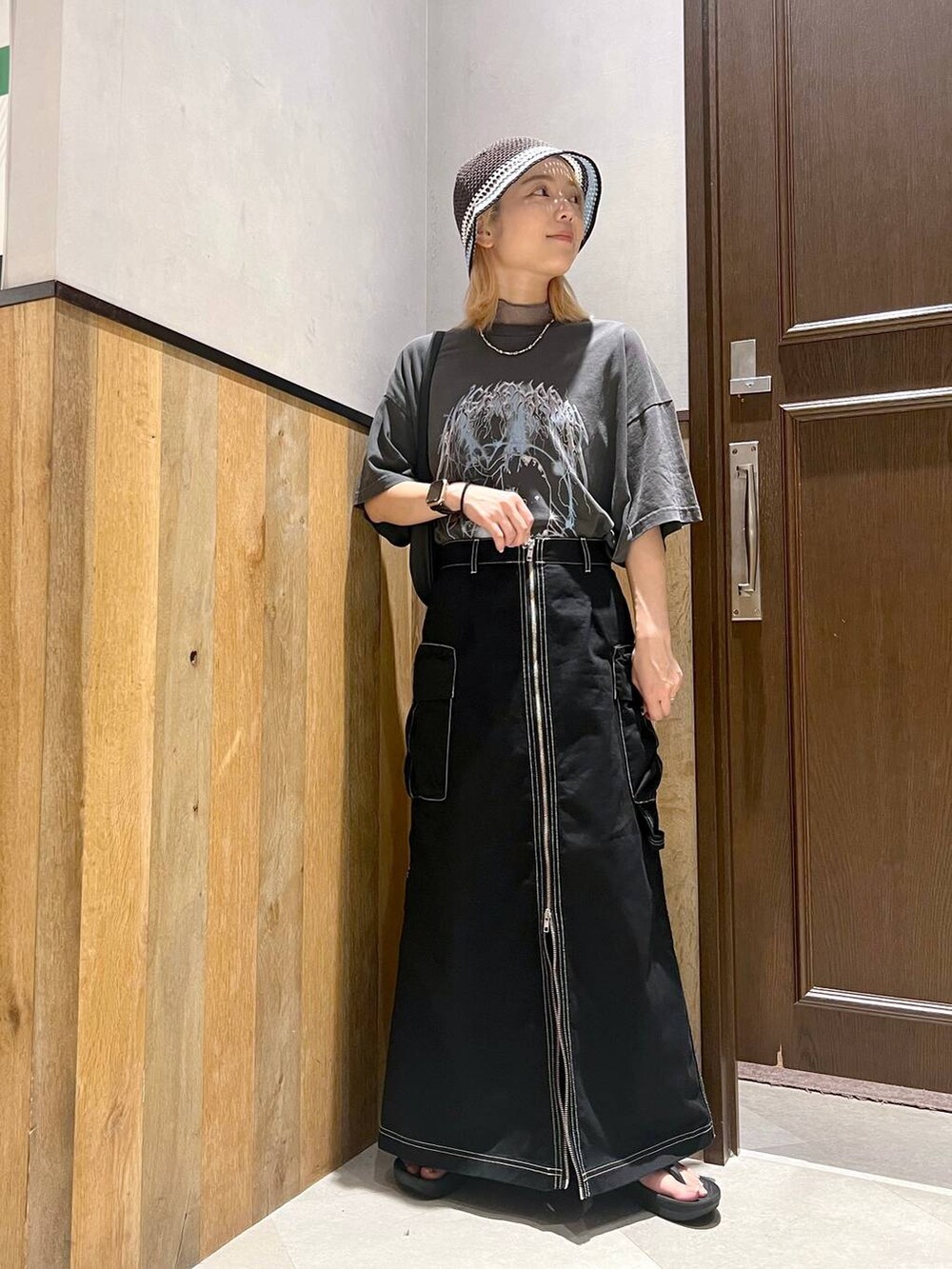 ブラック系のサンダル、グレー系のTシャツ/カットソー、ブラック系のデニムスカートを着用したレディースの夏コーディネートの4枚目の写真