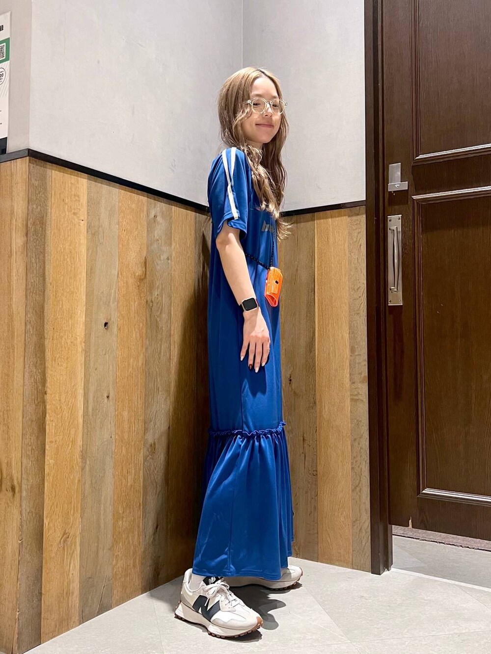 ホワイト系のワンピース、ホワイト系のスニーカー、オレンジ系のコインケースを着用したレディースの夏コーディネートの2枚目の写真