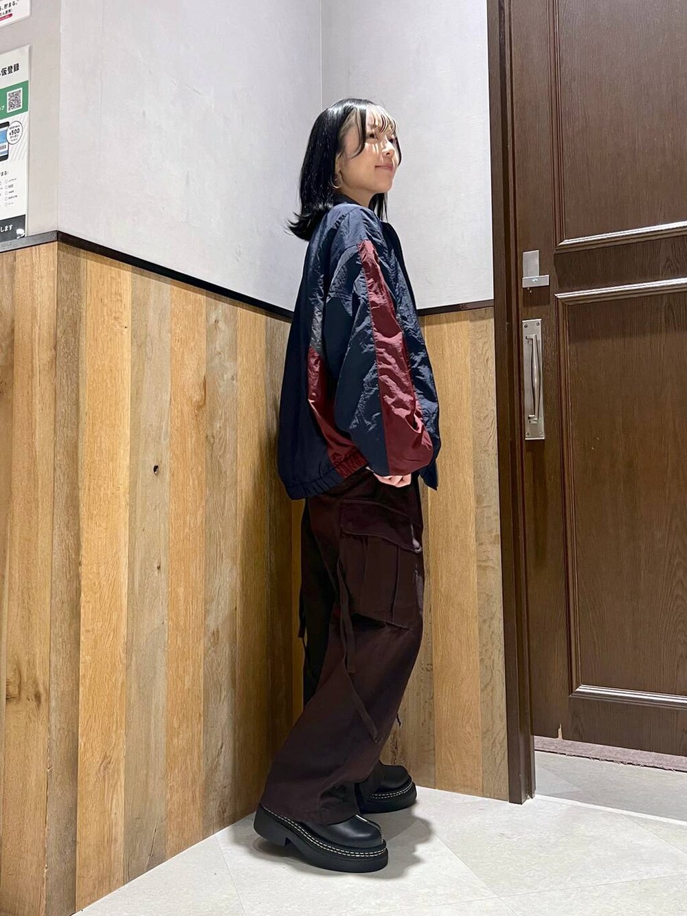ブラウン系のカーゴパンツ、ブルー系のブルゾン、ブラック系のTシャツ/カットソーを着用したレディースの秋コーディネートの2枚目の写真