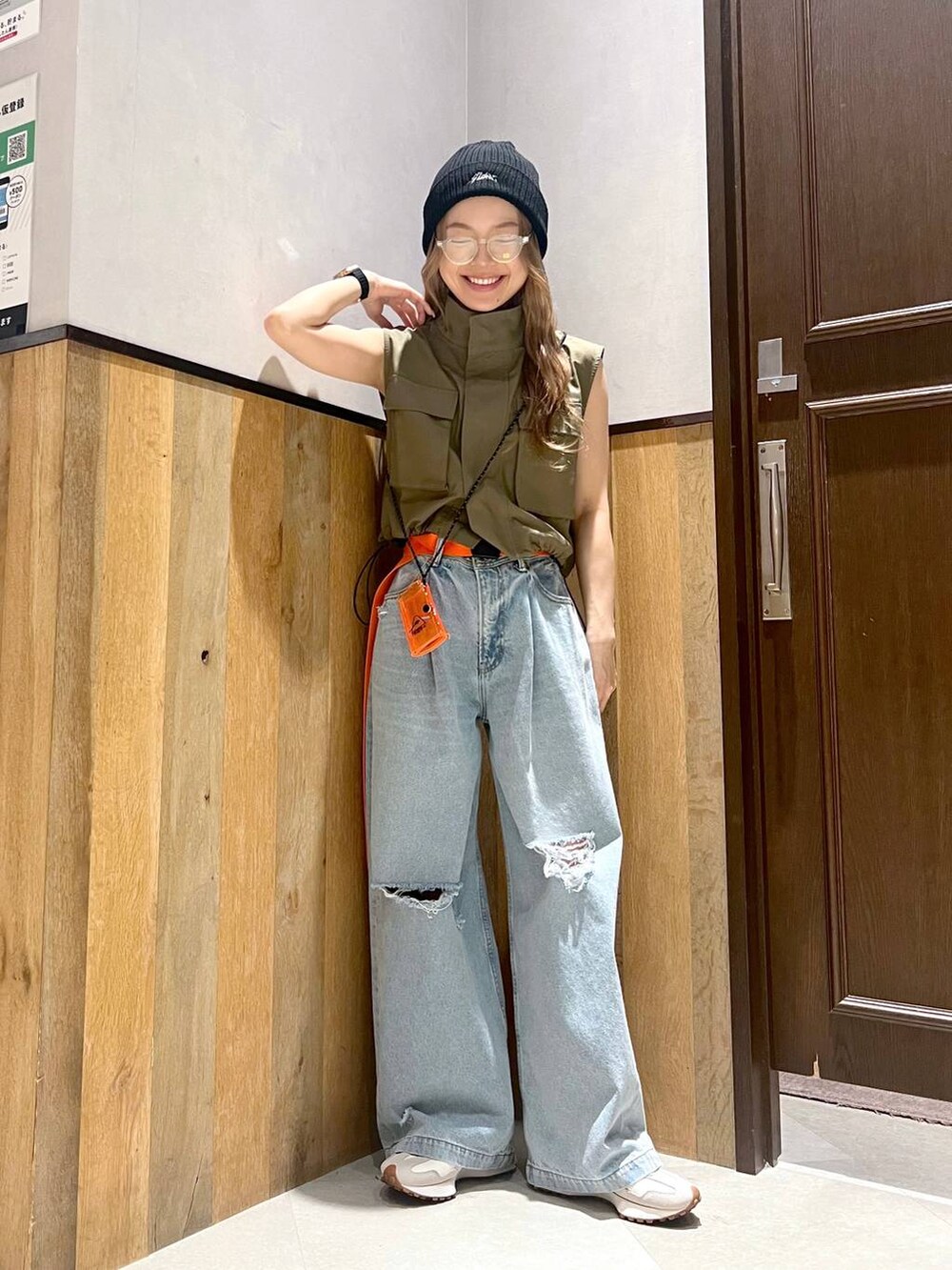 ブルー系のデニムパンツ、ブラック系のキャミソール、グリーン系のベストを着用したレディースの夏コーディネートの2枚目の写真