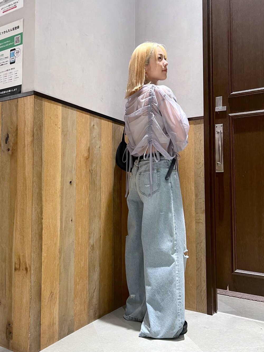 ブラック系のサンダル、ブルー系のデニムパンツ、ブラック系のショルダーバッグを着用したレディースの夏コーディネートの2枚目の写真