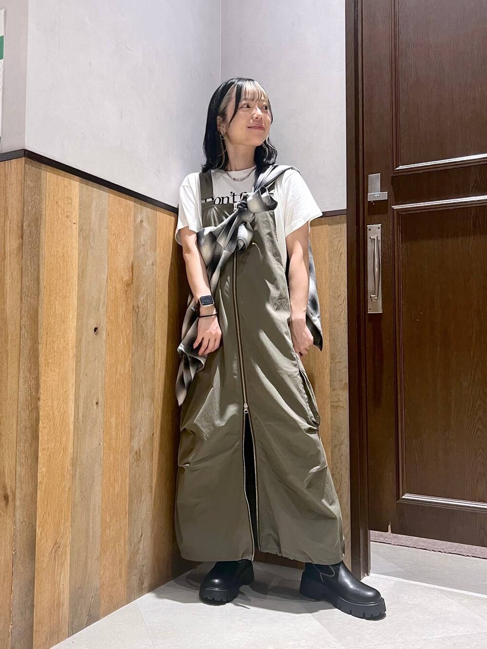 その他のTシャツ/カットソー、グリーン系のジャンパースカート、ブラック系のブーツを着用したレディースの秋コーディネートの4枚目の写真