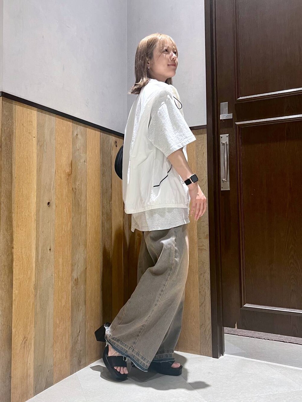 ブラック系のサンダル、ホワイト系のベスト、ホワイト系のTシャツ/カットソーを着用したレディースの夏コーディネートの2枚目の写真