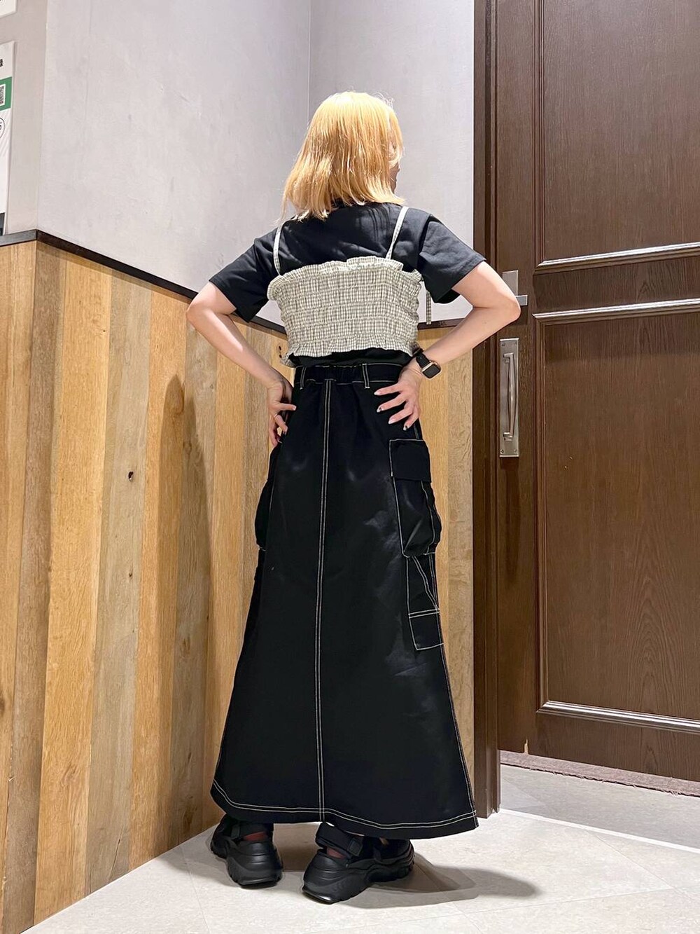 ブラック系のスニーカー、ブラック系のTシャツ/カットソー、ブラック系のデニムスカートを着用したレディースの夏コーディネートの4枚目の写真