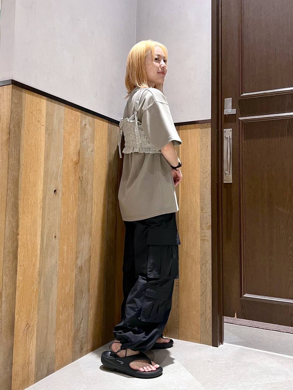 ブラック系のサンダル、ブラック系のカーゴパンツ、ホワイト系のシャツ/ブラウスを着用したレディースの夏コーディネートの2枚目の写真