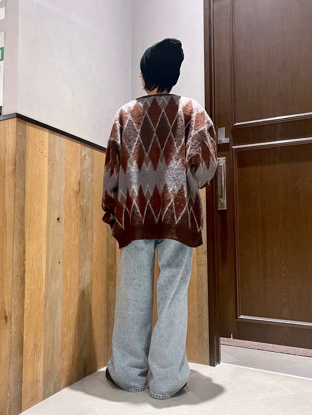 ブラウン系のカーディガン/ボレロ、ブルー系のデニムパンツ、ブラック系のローファーを着用したレディースの秋コーディネートの3枚目の写真