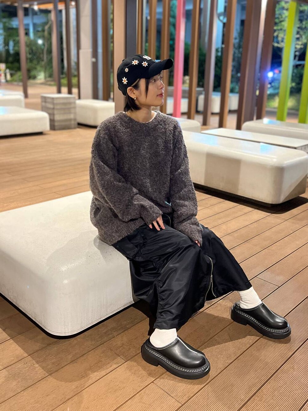 ブラック系のスカート、ブラック系のローファー、ブラウン系のニット/セーターを着用したレディースの秋コーディネートの4枚目の写真