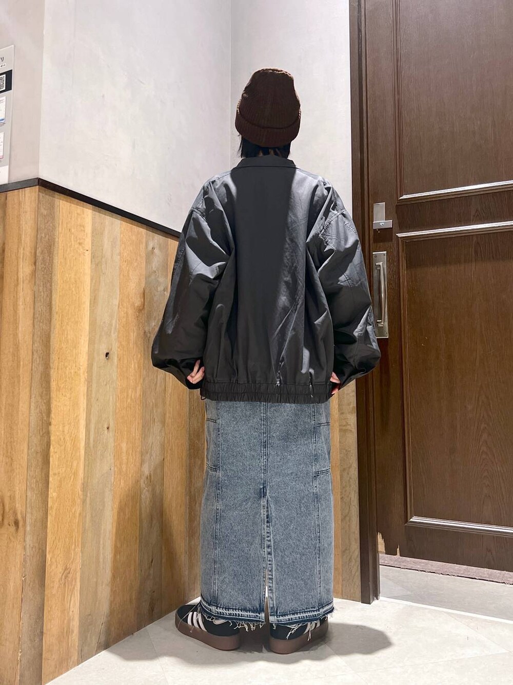 ブルー系のデニムスカート、ブラック系のブルゾン、イエロー系のスウェットを着用したレディースの秋コーディネートの7枚目の写真