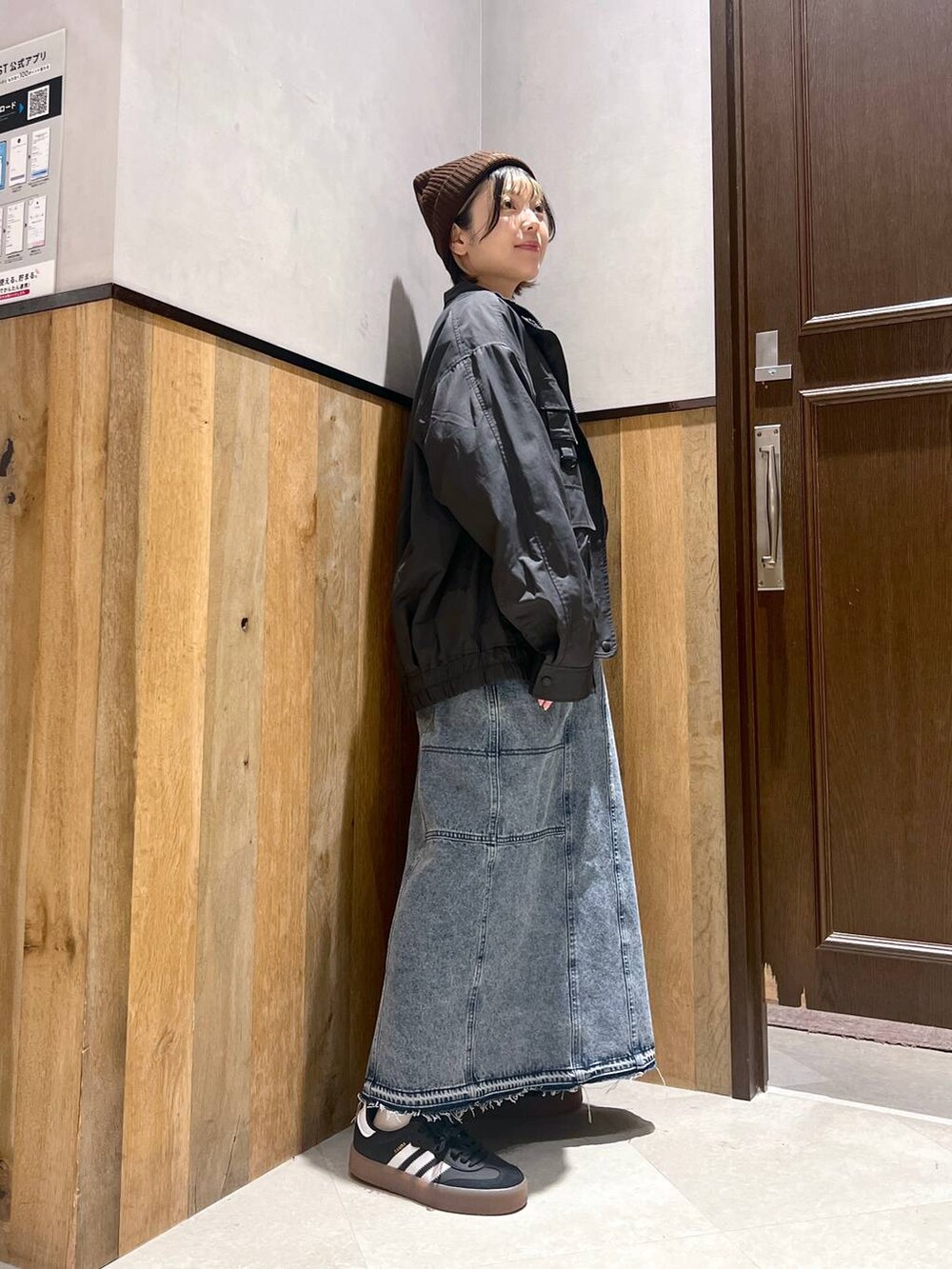 ブルー系のデニムスカート、ブラック系のブルゾン、イエロー系のスウェットを着用したレディースの秋コーディネートの6枚目の写真