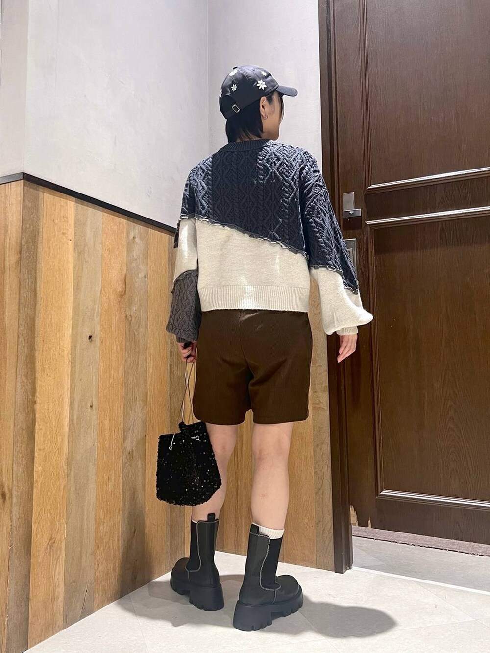 ホワイト系のダウンジャケット/コート、ブラック系のブーツ、ブラック系のハンドバッグを着用したレディースの秋コーディネートの7枚目の写真