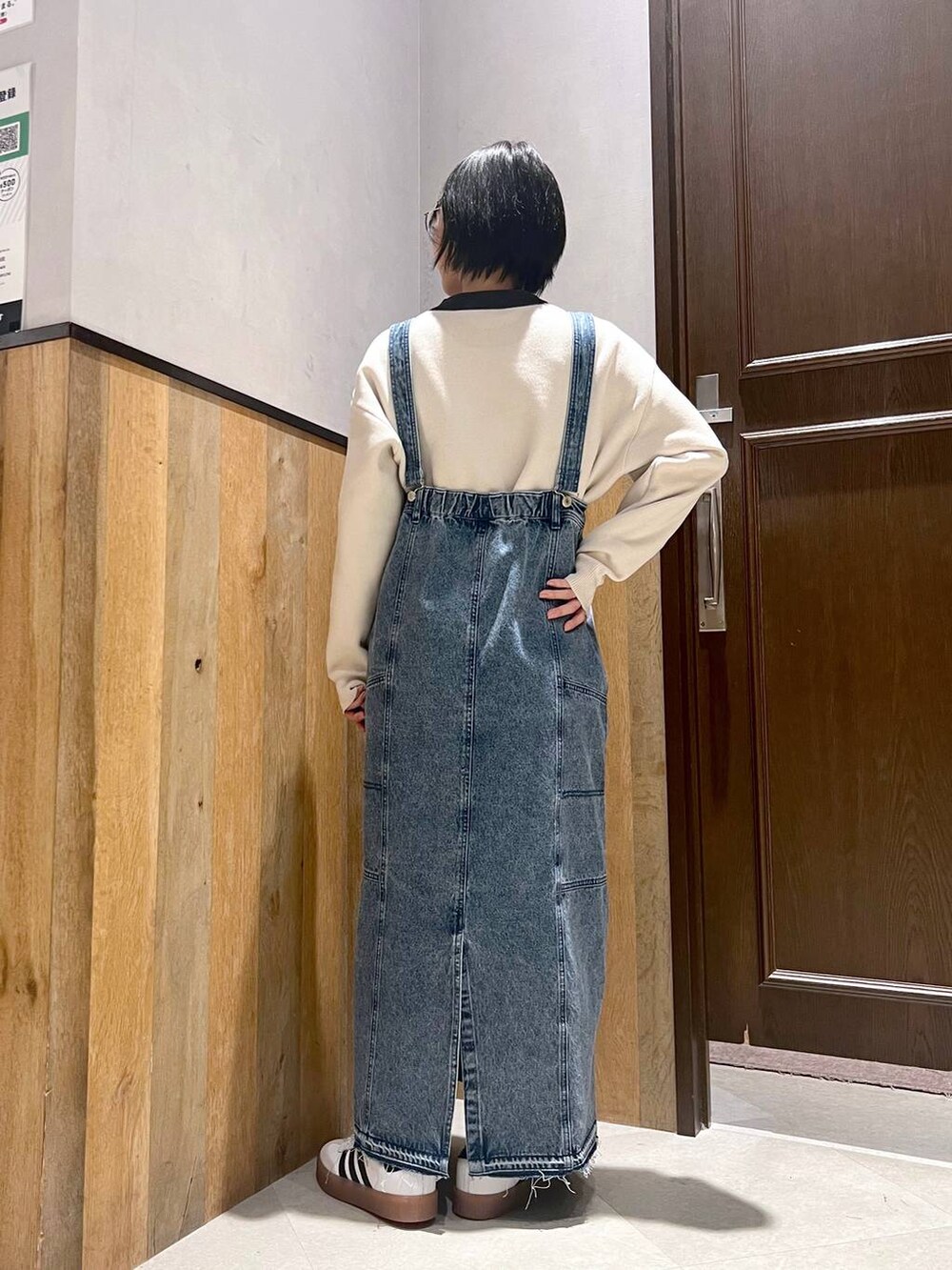 ブルー系のデニムスカート、ホワイト系のニット/セーター、ホワイト系のスニーカーを着用したレディースの秋コーディネートの4枚目の写真