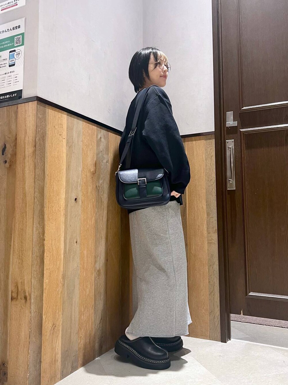 ブラック系のステンカラーコート、ブラック系のローファー、その他のスカートを着用したレディースの秋コーディネートの9枚目の写真