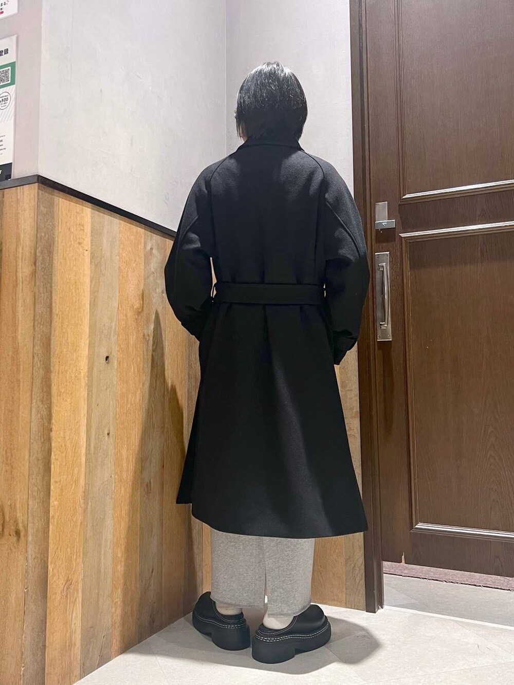 ブラック系のステンカラーコート、ブラック系のローファー、その他のスカートを着用したレディースの秋コーディネートの3枚目の写真