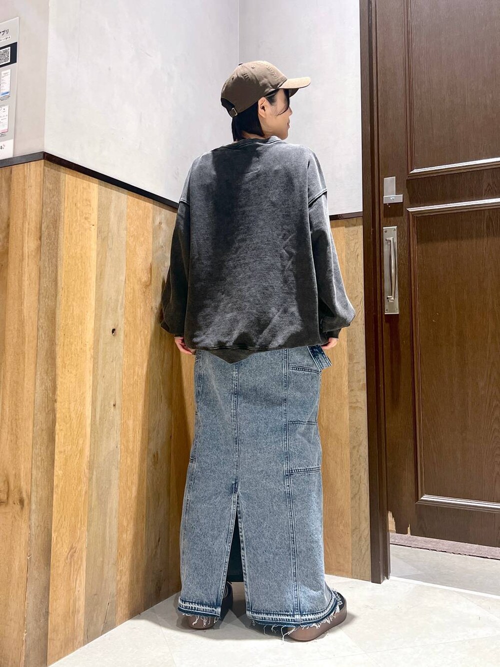 ブルー系のデニムスカート、ブラック系のスニーカー、グレー系のスウェットを着用したレディースの秋コーディネートの3枚目の写真