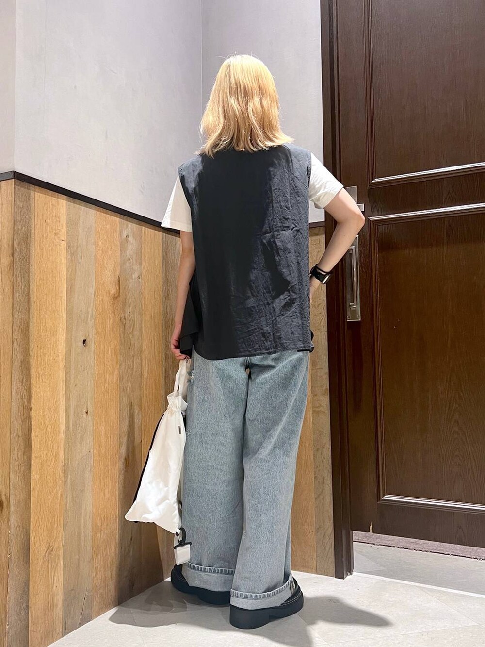 ホワイト系のショルダーバッグ、ホワイト系のTシャツ/カットソー、ブルー系のデニムパンツを着用したレディースの夏コーディネートの3枚目の写真